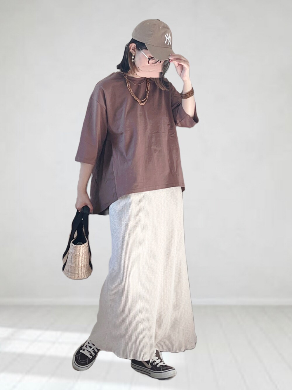 ブラウン系のTシャツ/カットソー、ホワイト系のスカート、ブラック系のトートバッグを着用したレディースの夏コーディネートの2枚目の写真