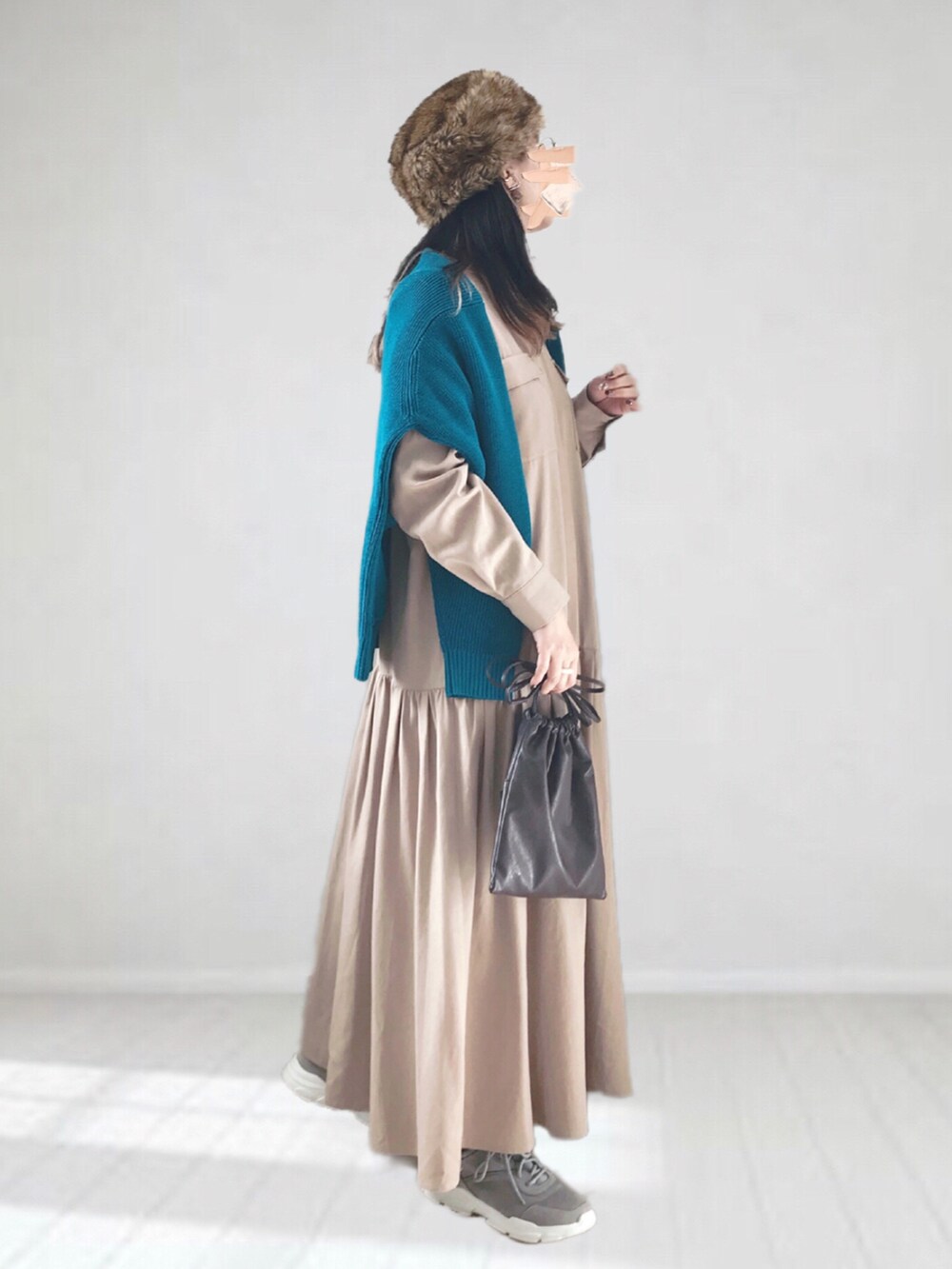 ブルー系のカーディガン/ボレロ、ベージュ系のワンピース、ブラウン系のハンドバッグを着用したレディースの冬コーディネートの3枚目の写真