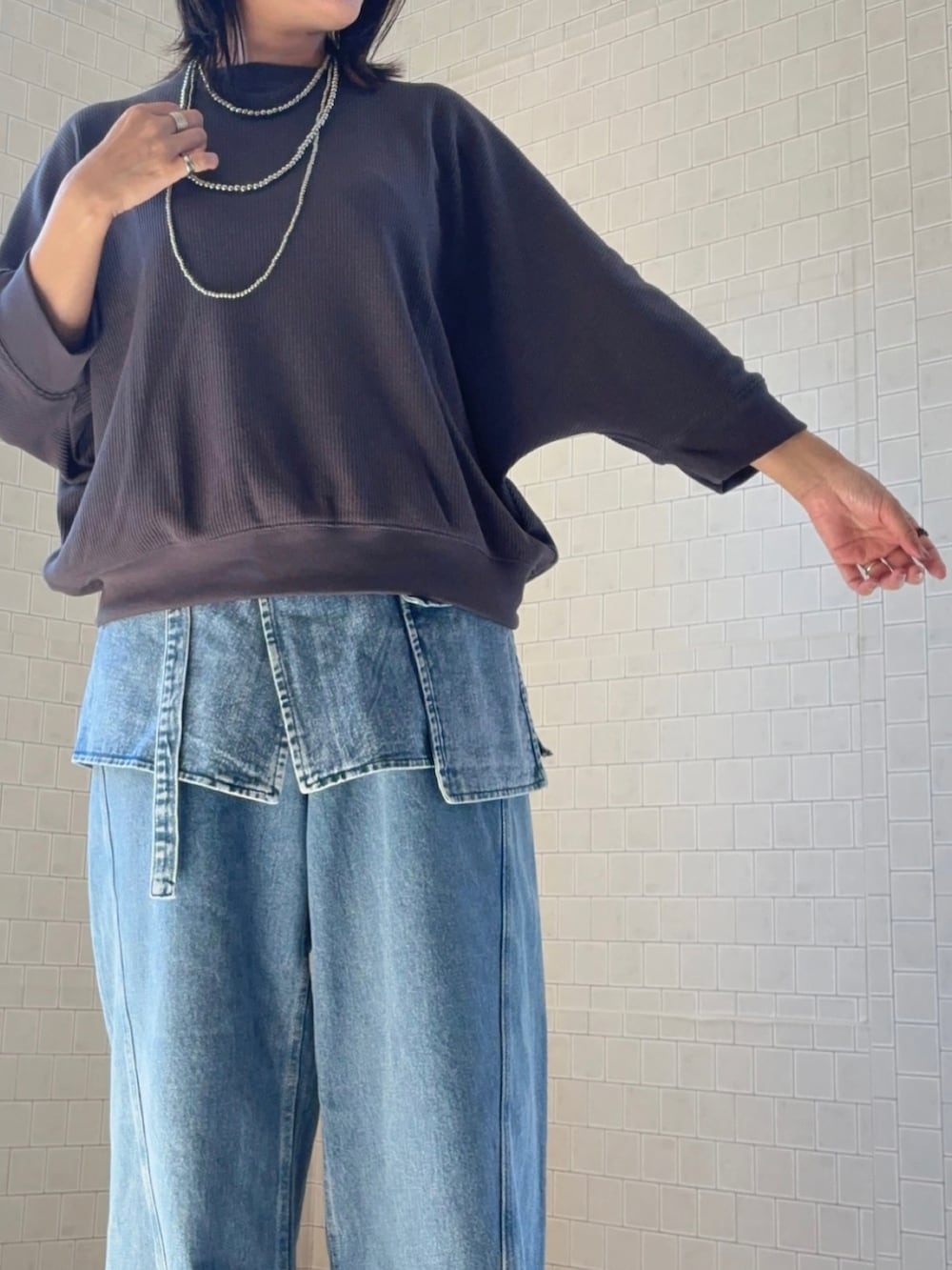 グレー系のTシャツ/カットソー、ブルー系のデニムパンツを着用したレディースの秋コーディネートの5枚目の写真