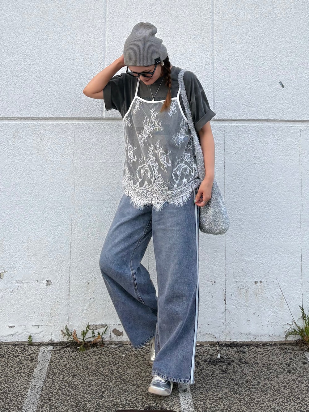 ブルー系のデニムパンツ、シルバー系のトートバッグ、シルバー系のスニーカーを着用したレディースの夏コーディネートの2枚目の写真