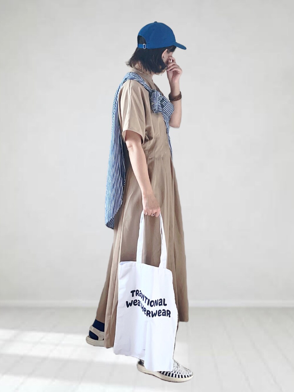 ベージュ系のワンピース、ブルー系のシャツ/ブラウス、ホワイト系のトートバッグを着用したレディースの夏コーディネートの3枚目の写真