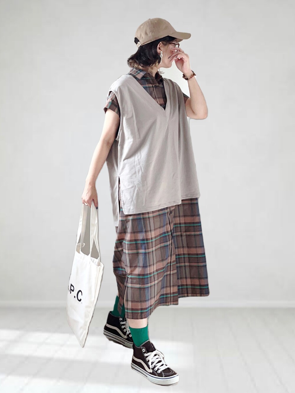 ブラウン系のワンピース、ベージュ系のベスト、ホワイト系のトートバッグを着用したレディースの夏コーディネートの3枚目の写真