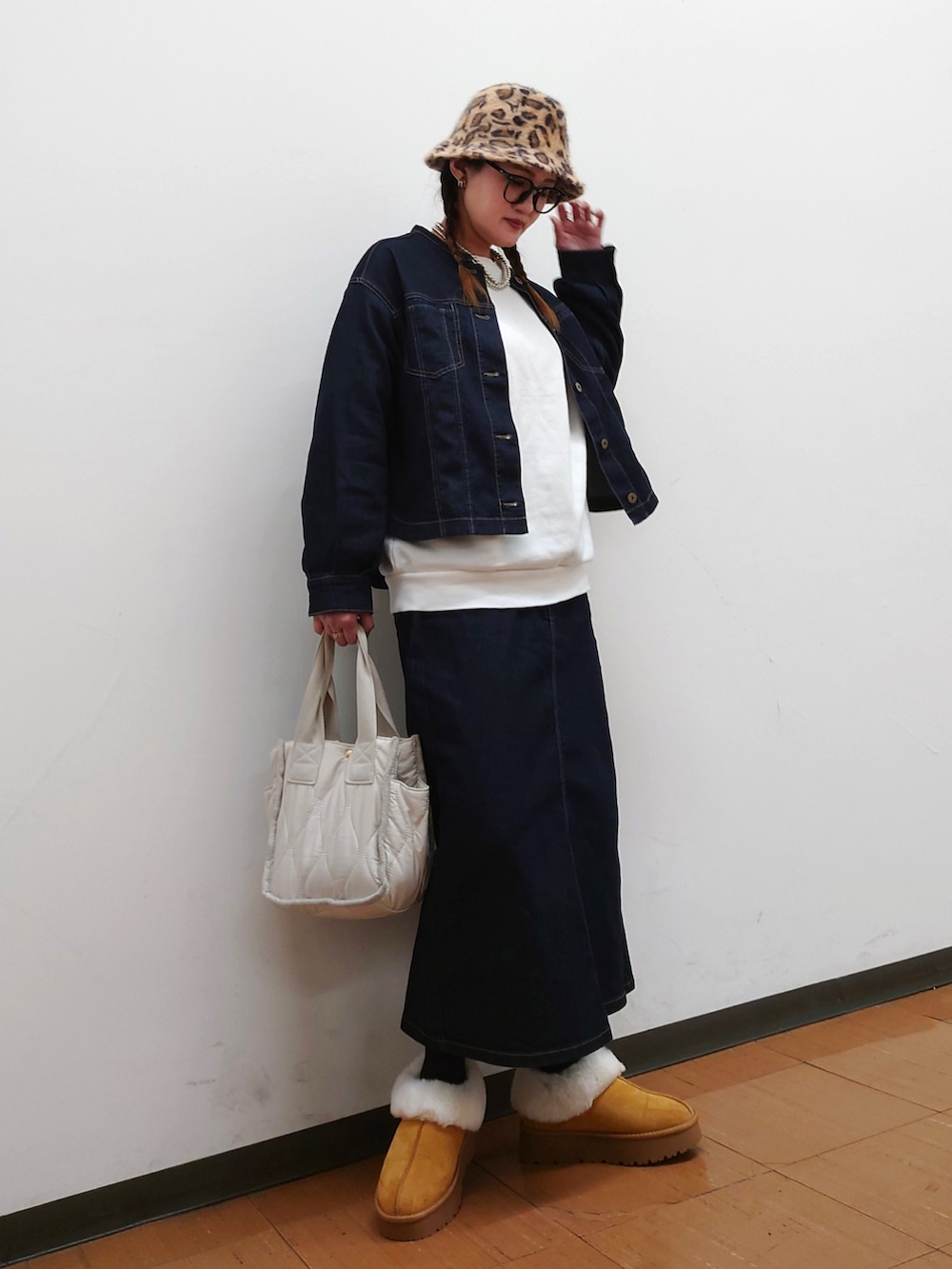 ブルー系のブルゾン、ホワイト系のトートバッグ、イエロー系のブーツを着用したレディースの冬コーディネートの4枚目の写真