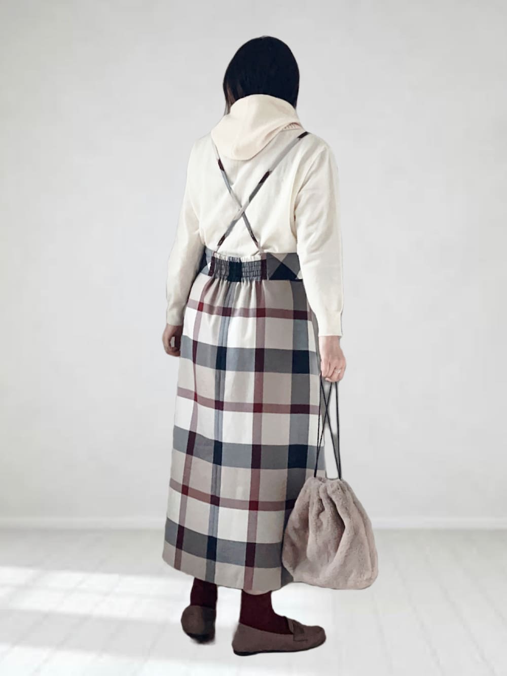 ベージュ系のスカート、ホワイト系のニット/セーター、ブラック系のショルダーバッグを着用したレディースの秋コーディネートの2枚目の写真