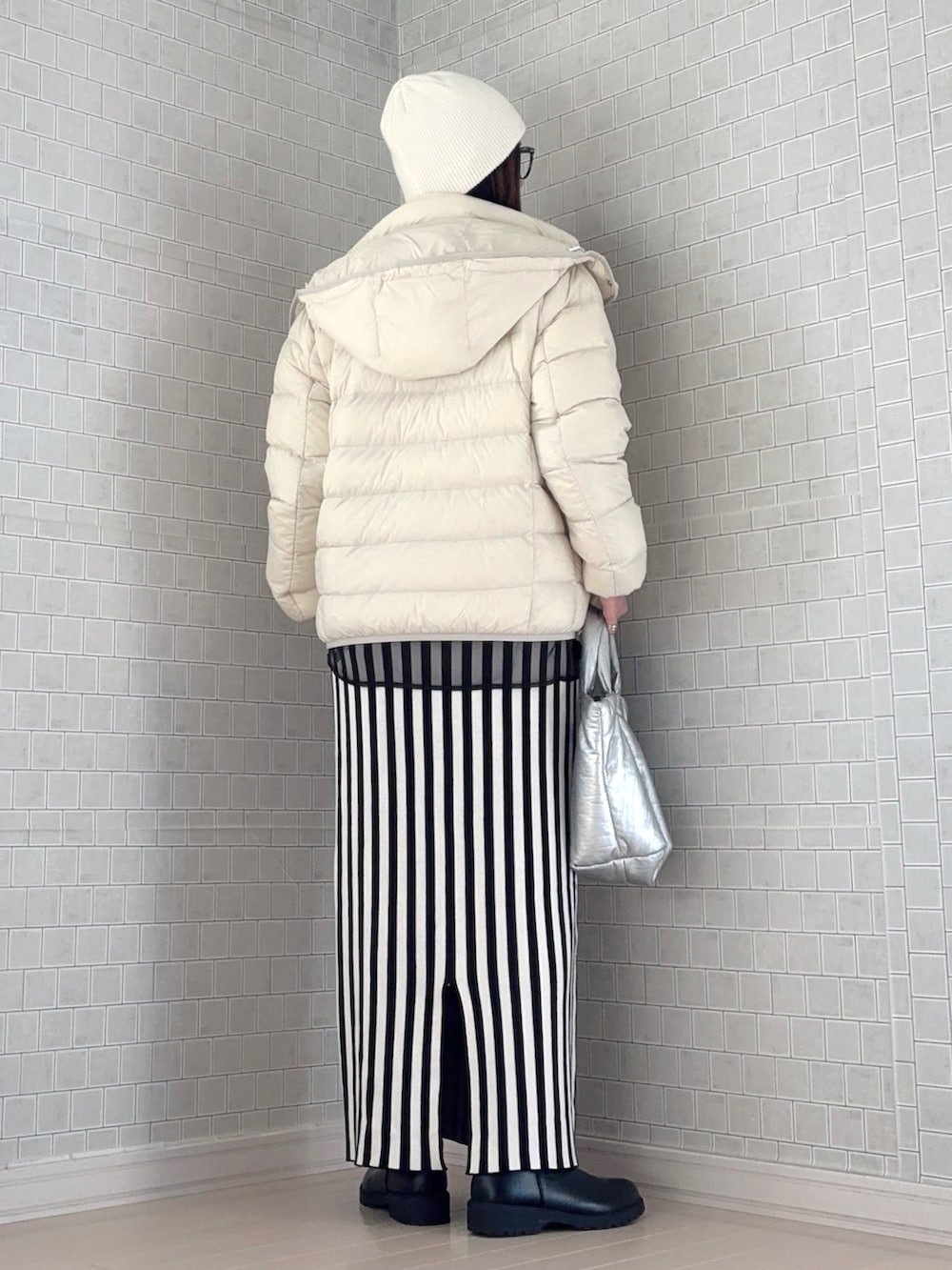 ホワイト系のダウンジャケット/コート、ブラック系のスウェット、ホワイト系のスカートを着用したレディースの秋コーディネートの4枚目の写真