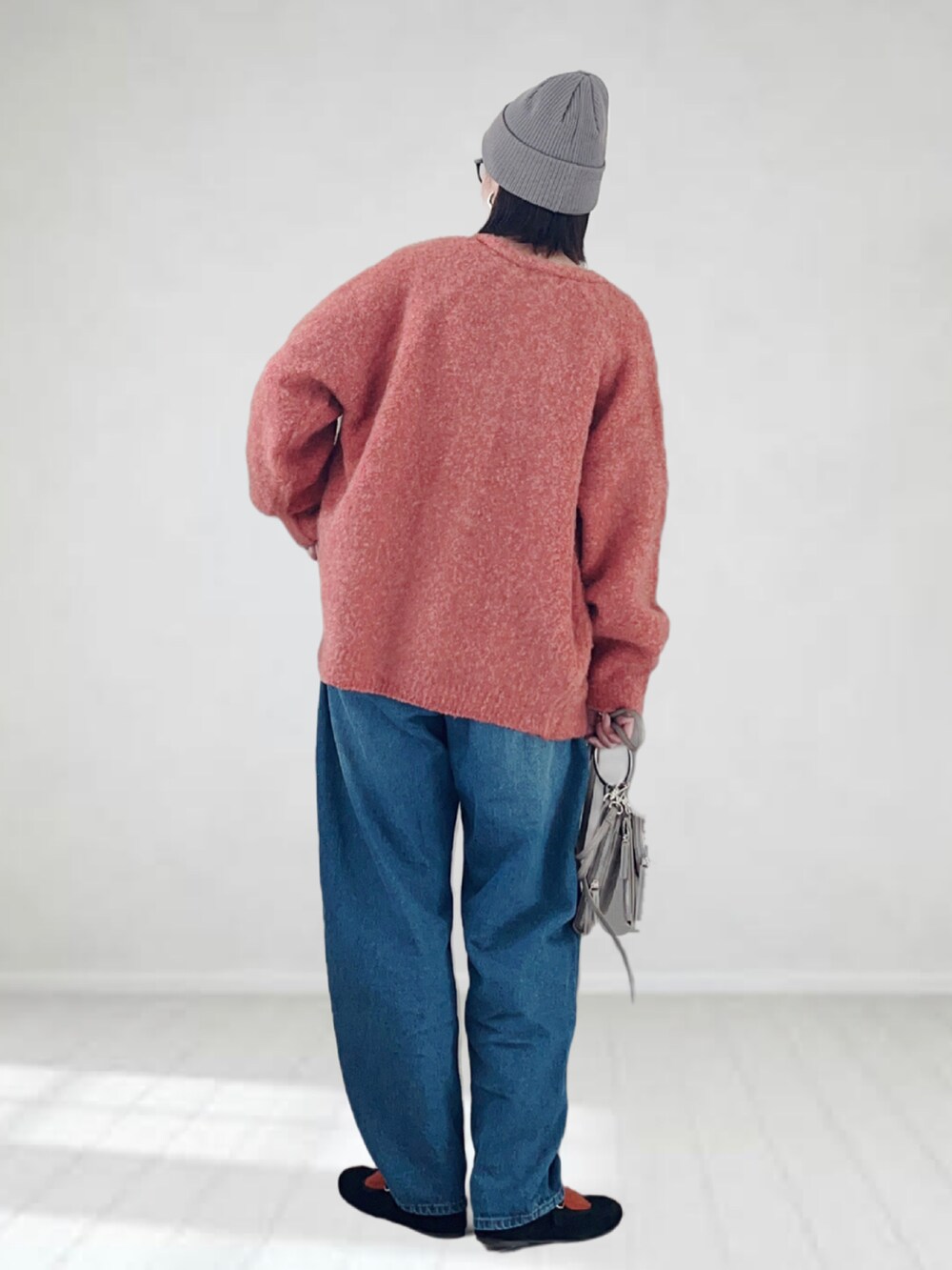 グレー系のTシャツ/カットソー、ピンク系のカーディガン/ボレロ、ブルー系のデニムパンツを着用したレディースの秋コーディネートの2枚目の写真
