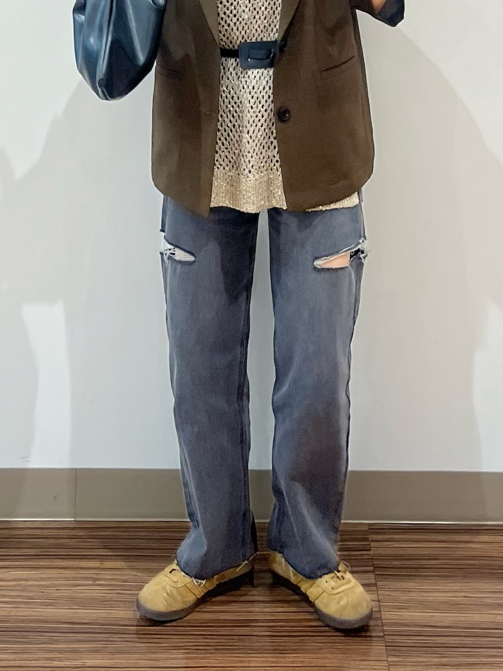 ブラック系のデニムパンツ、ブラウン系のテーラードジャケット、ゴールド系のベストを着用したレディースの夏コーディネートの3枚目の写真