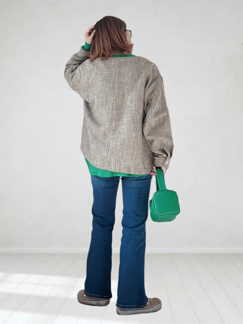 ブルー系のデニムパンツ、グリーン系のTシャツ/カットソー、グリーン系のショルダーバッグを着用したレディースの春コーディネートの3枚目の写真