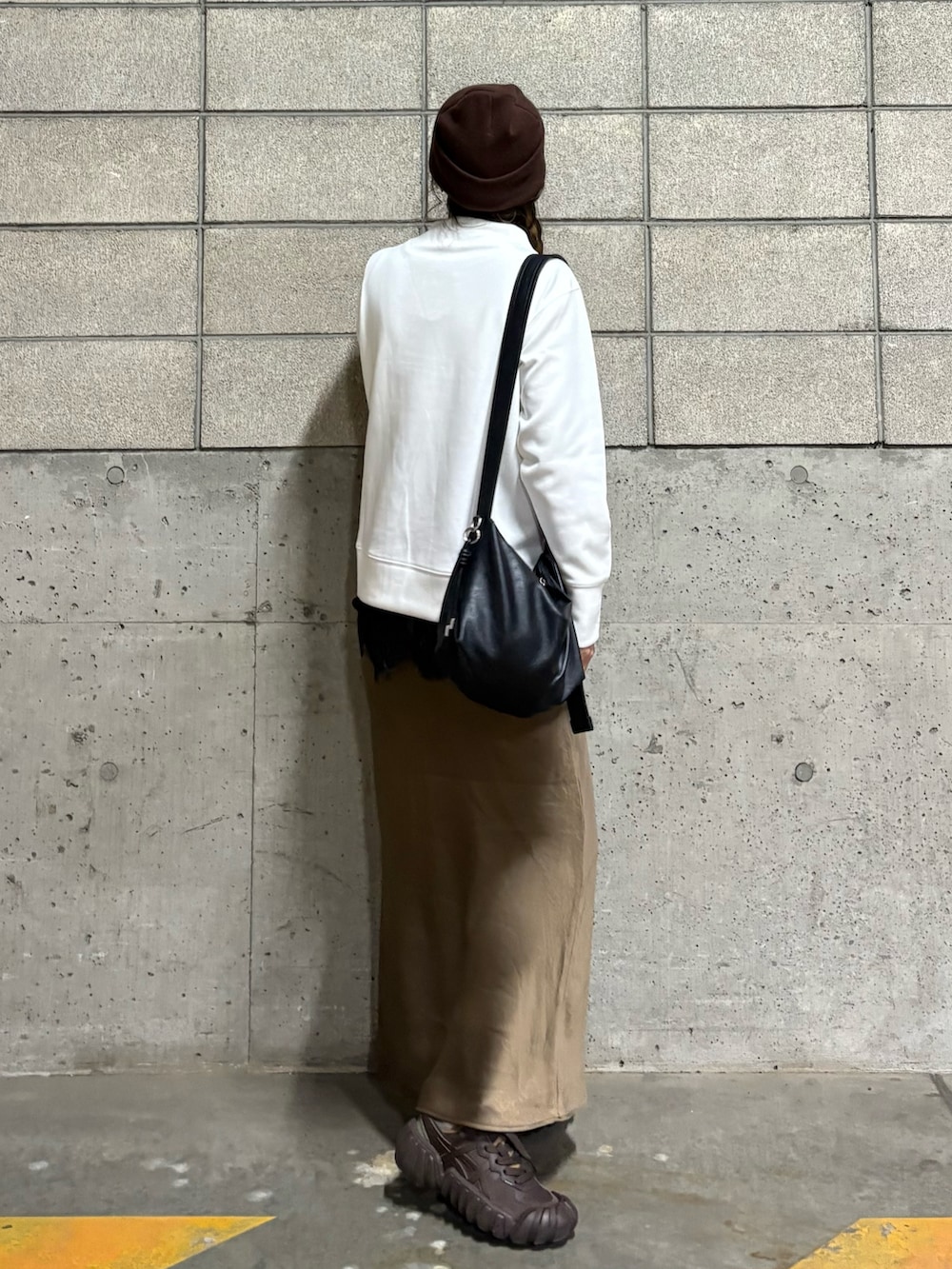 ホワイト系のスウェット、ブラウン系のスニーカー、ブラック系のショルダーバッグを着用したレディースの春コーディネートの3枚目の写真