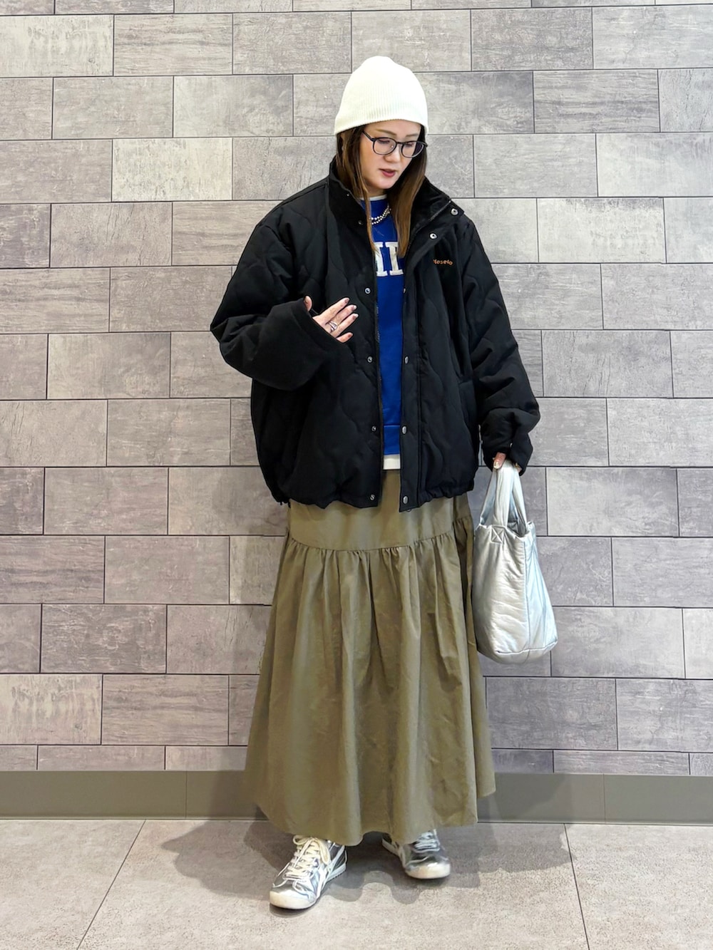 ブラック系のブルゾン、ブルー系のスウェット、グリーン系のスカートを着用したレディースの秋コーディネートの2枚目の写真