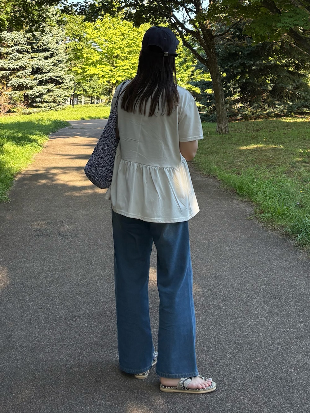 グレー系のTシャツ/カットソー、ブルー系のかごバッグ、ブルー系のデニムパンツを着用したレディースの夏コーディネートの2枚目の写真