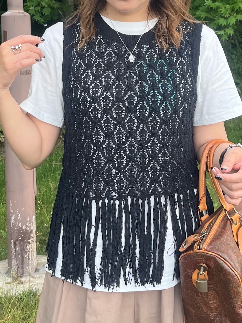 ブラック系のベスト、ブラウン系のスラックス、ホワイト系のTシャツ/カットソーを着用したレディースの夏コーディネートの3枚目の写真