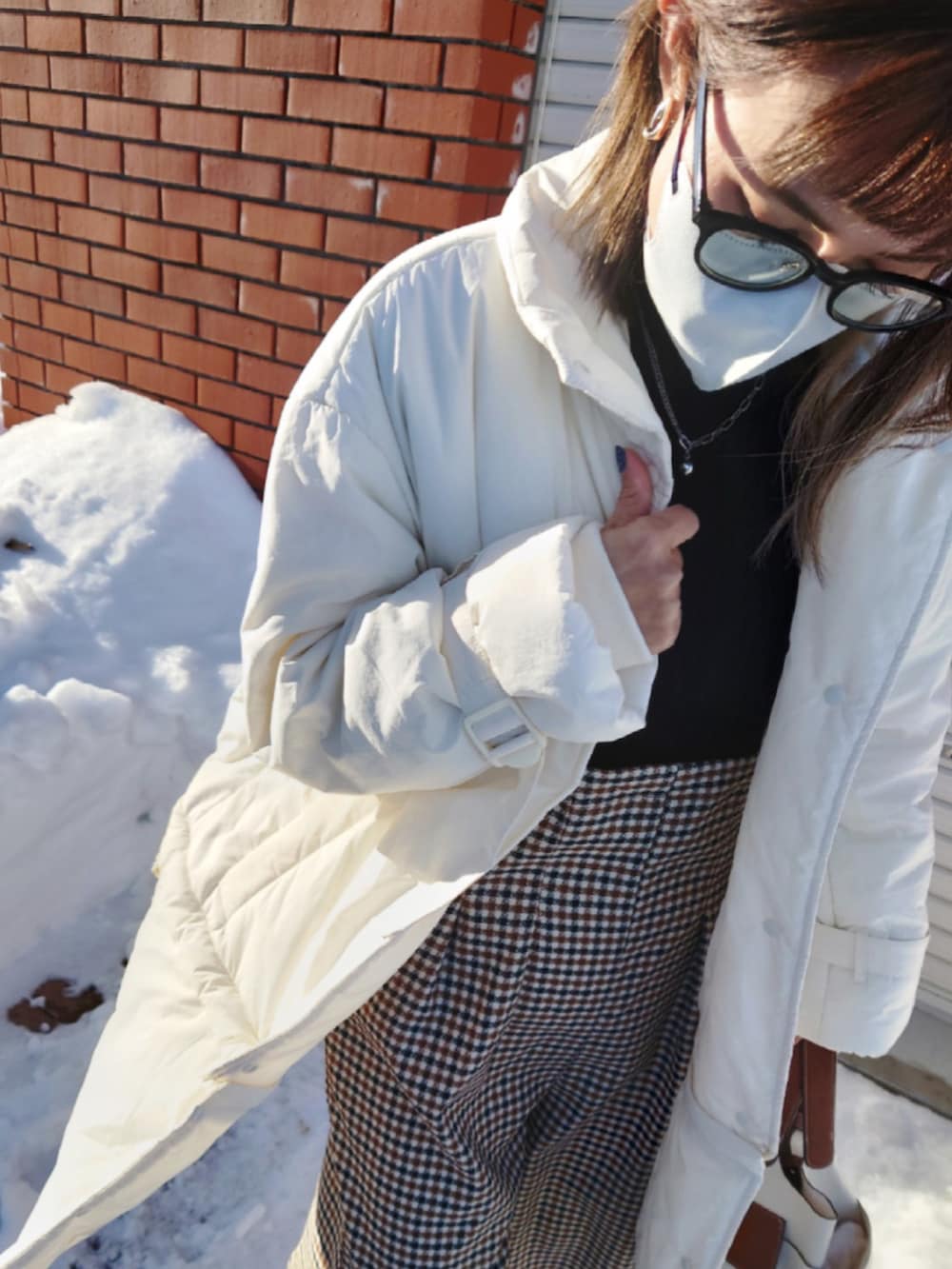 ホワイト系のその他アウター、ブラック系のニット/セーター、ベージュ系のサロペット/オーバーオールを着用したレディースの冬コーディネートの2枚目の写真