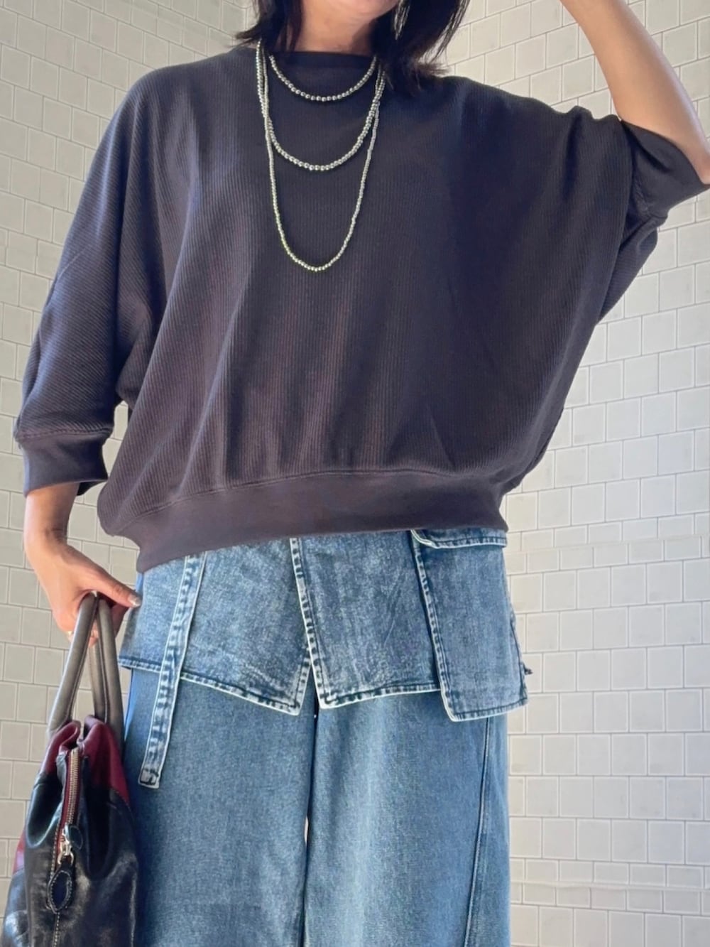 グレー系のTシャツ/カットソー、ブルー系のデニムパンツを着用したレディースの秋コーディネートの4枚目の写真