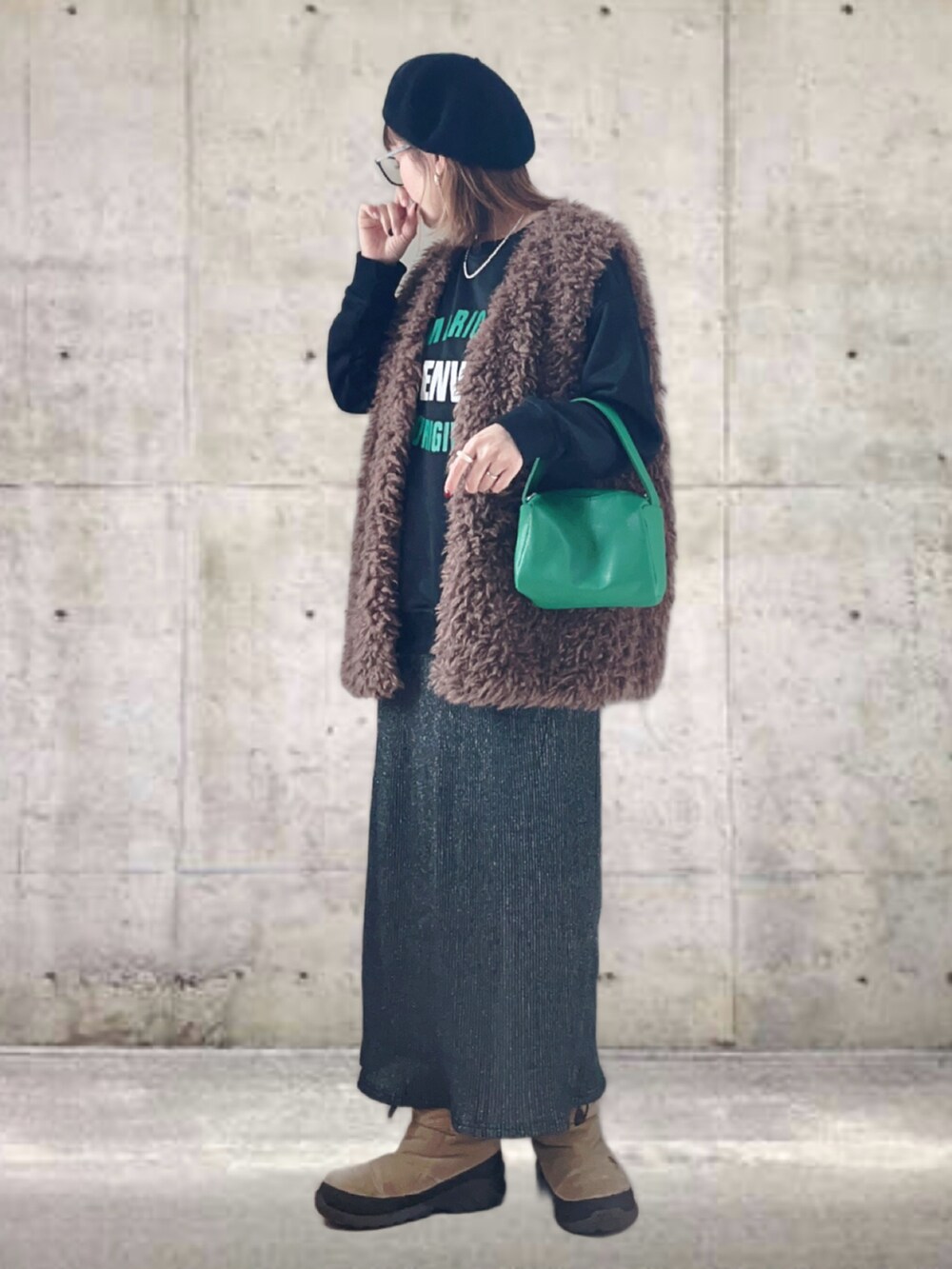 ブラック系のスウェット、ブラウン系のベスト、グレー系のスカートを着用したレディースの冬コーディネートの3枚目の写真