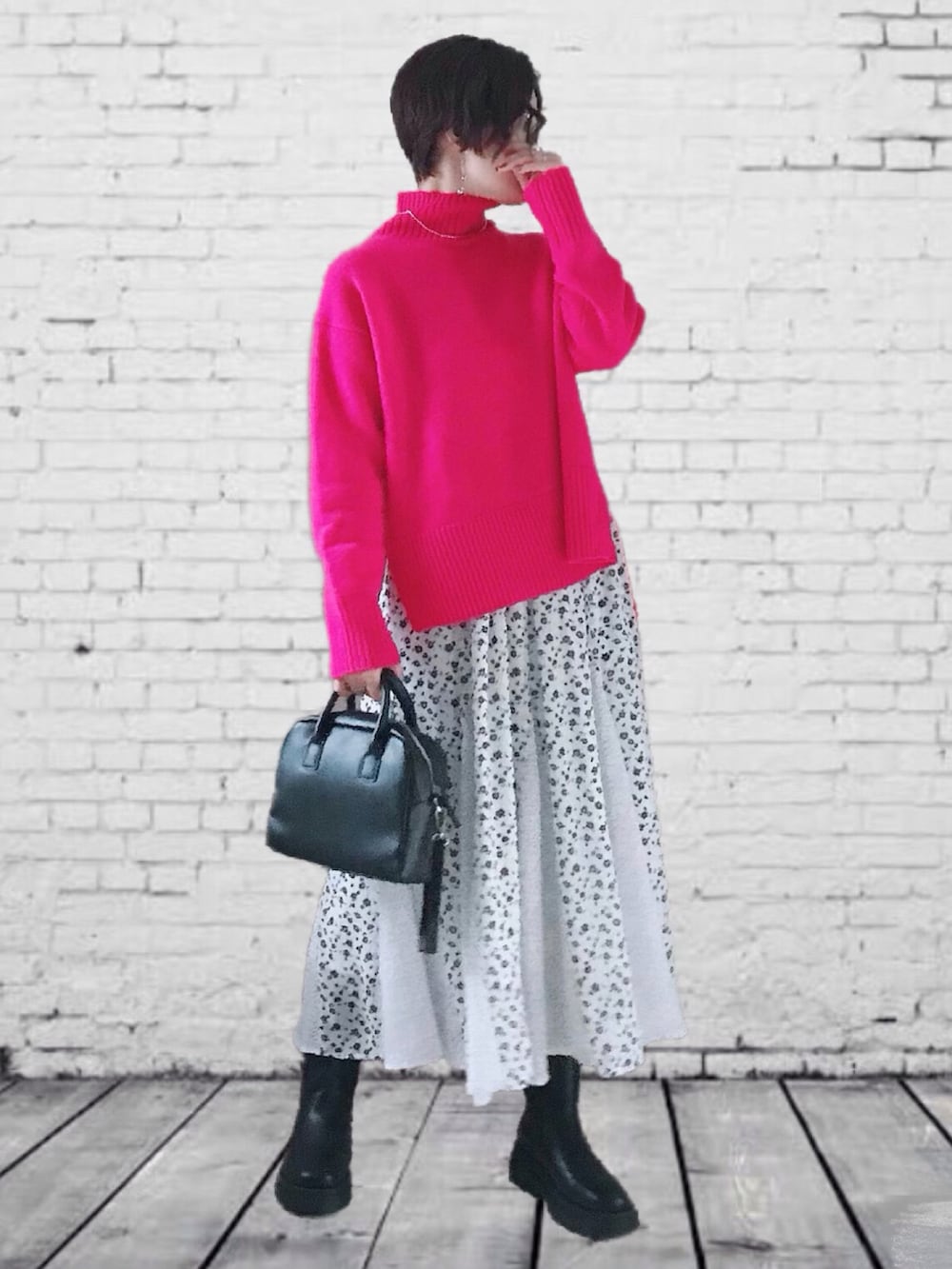 ピンク系のニット/セーター、ホワイト系のスカート、ブラック系のブーツを着用したレディースの秋コーディネートの2枚目の写真