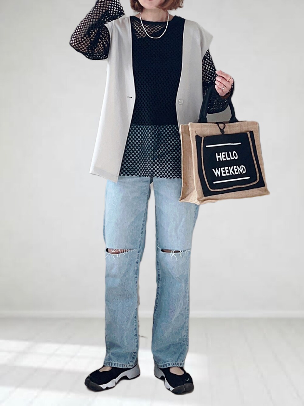 ブルー系のデニムパンツ、ベージュ系のベスト、ブラック系のTシャツ/カットソーを着用したレディースの春コーディネートの3枚目の写真