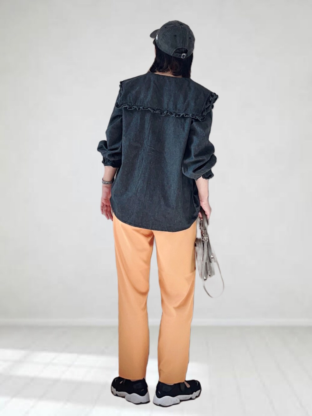 ブラック系のシャツ/ブラウス、ホワイト系のタンクトップ、オレンジ系のスラックスを着用したレディースの夏コーディネートの2枚目の写真