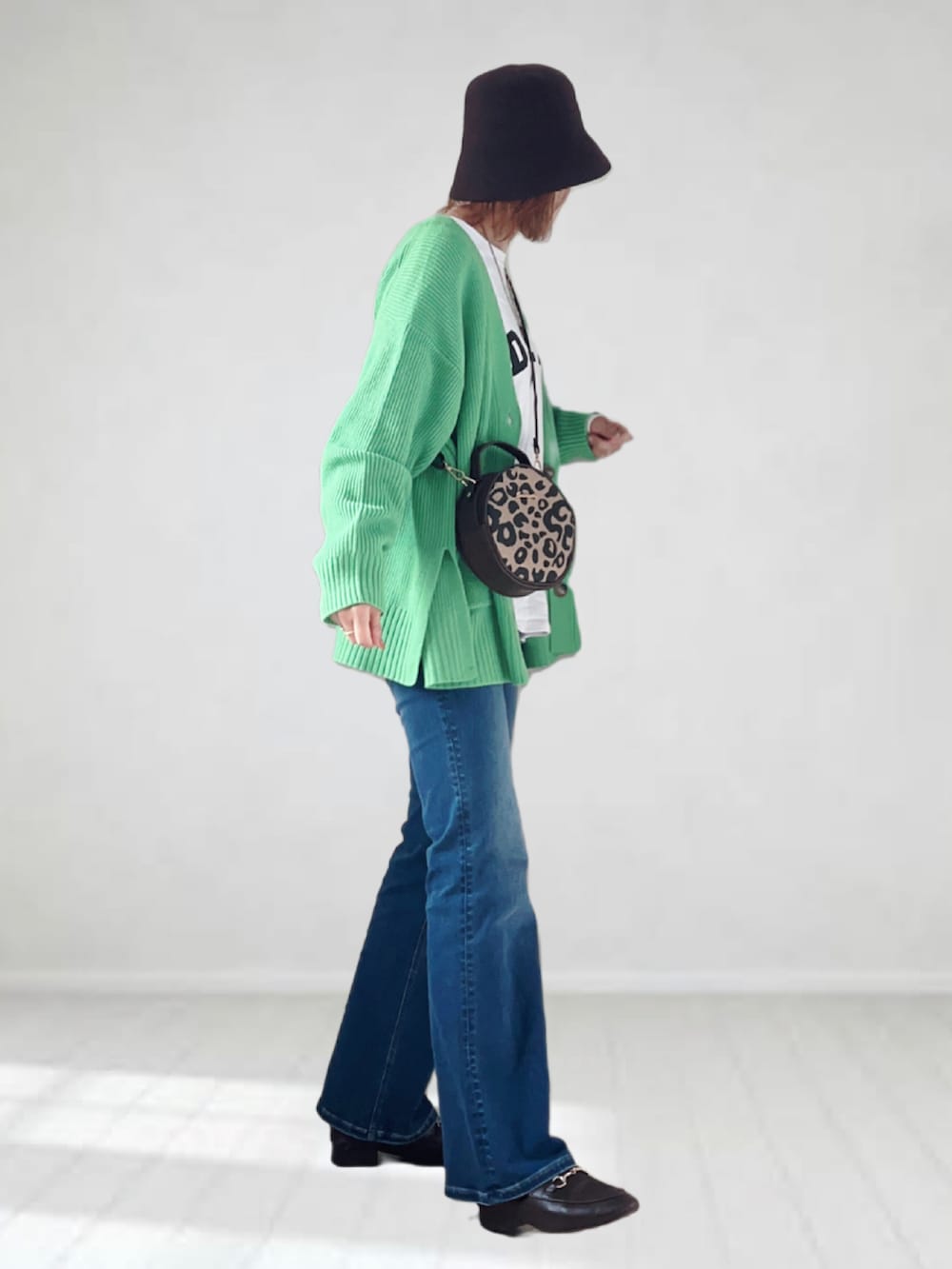 ブルー系のデニムパンツ、ホワイト系のTシャツ/カットソー、グリーン系のカーディガン/ボレロを着用したレディースの春コーディネートの3枚目の写真