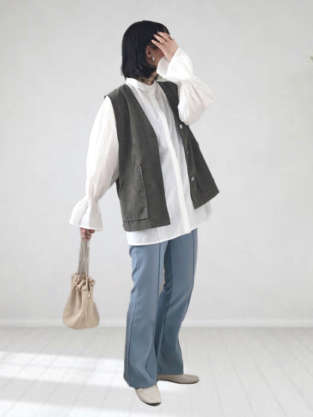 ホワイト系のシャツ/ブラウス、ブルー系のその他パンツ、グリーン系のベストを着用したレディースの冬コーディネートの2枚目の写真