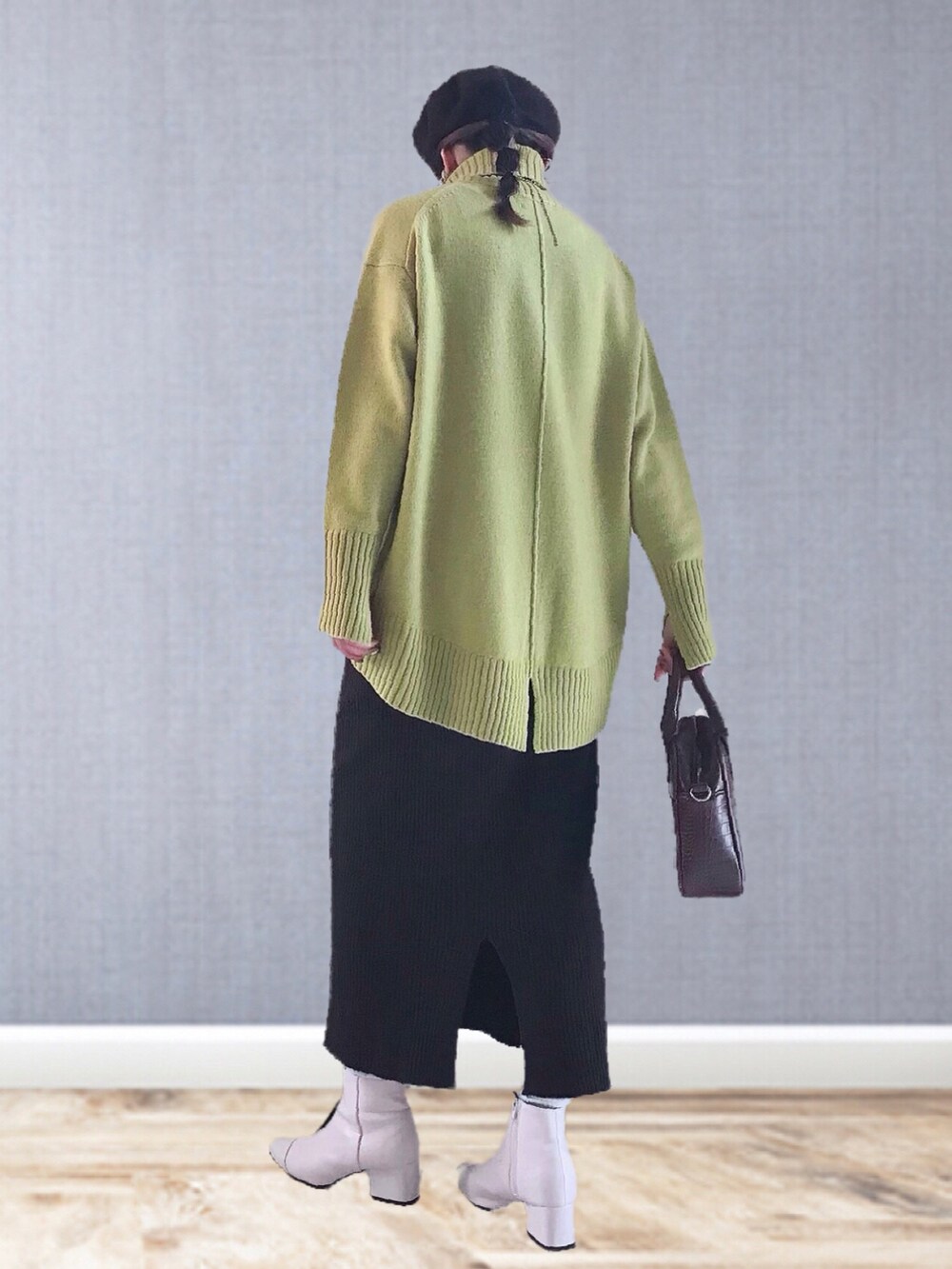 イエロー系のニット/セーター、ブラウン系のスカート、ブラウン系のハンドバッグを着用したレディースの冬コーディネートの3枚目の写真