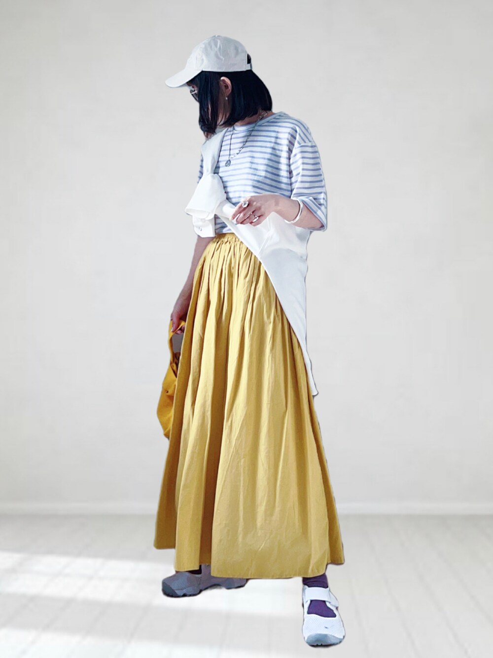 パープル系のTシャツ/カットソー、ホワイト系のシャツ/ブラウス、イエロー系のスカートを着用したレディースの春コーディネートの2枚目の写真