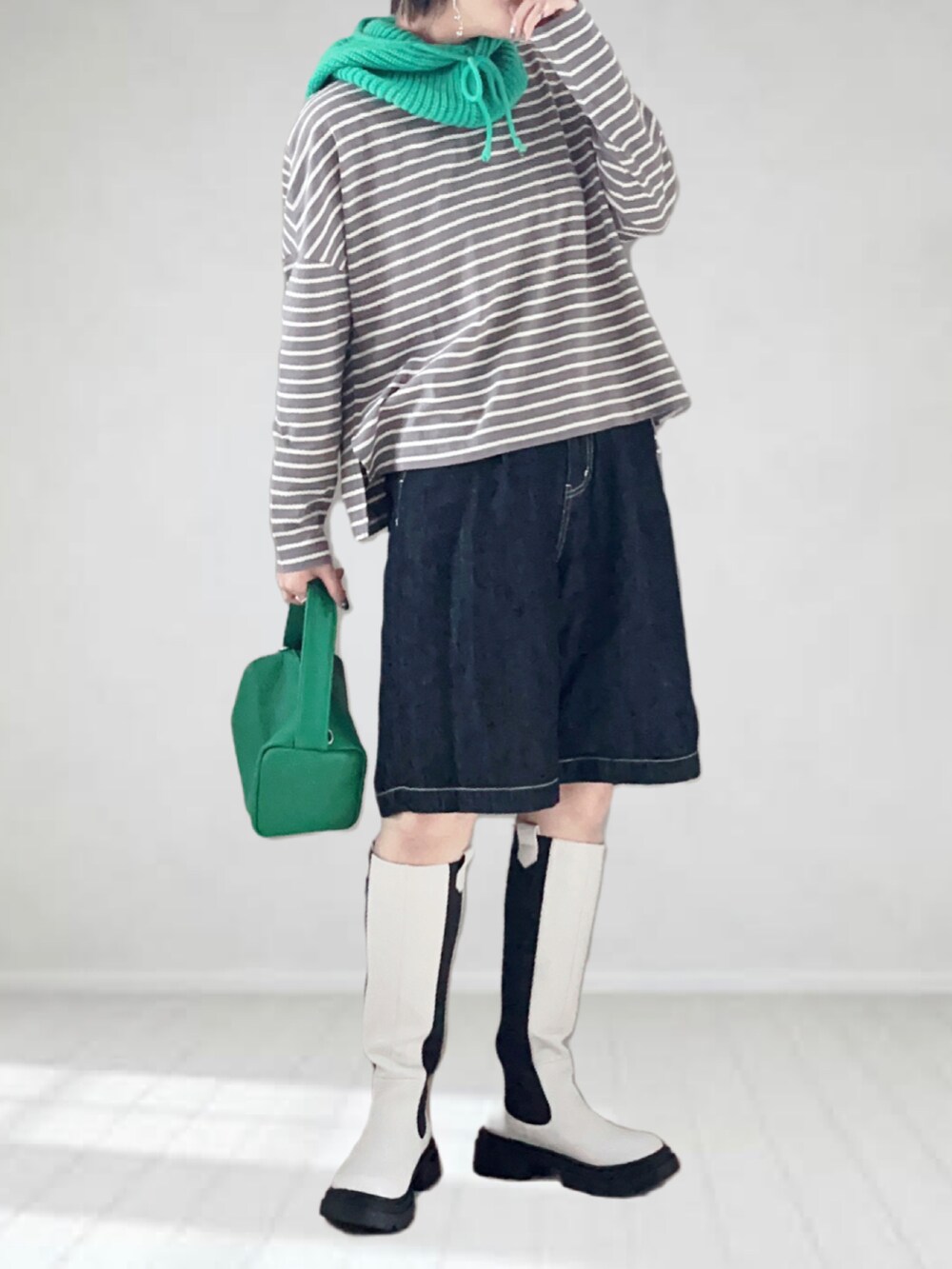 グレー系のTシャツ/カットソー、ホワイト系のブーツ、ブラック系のデニムパンツを着用したレディースの秋コーディネートの2枚目の写真