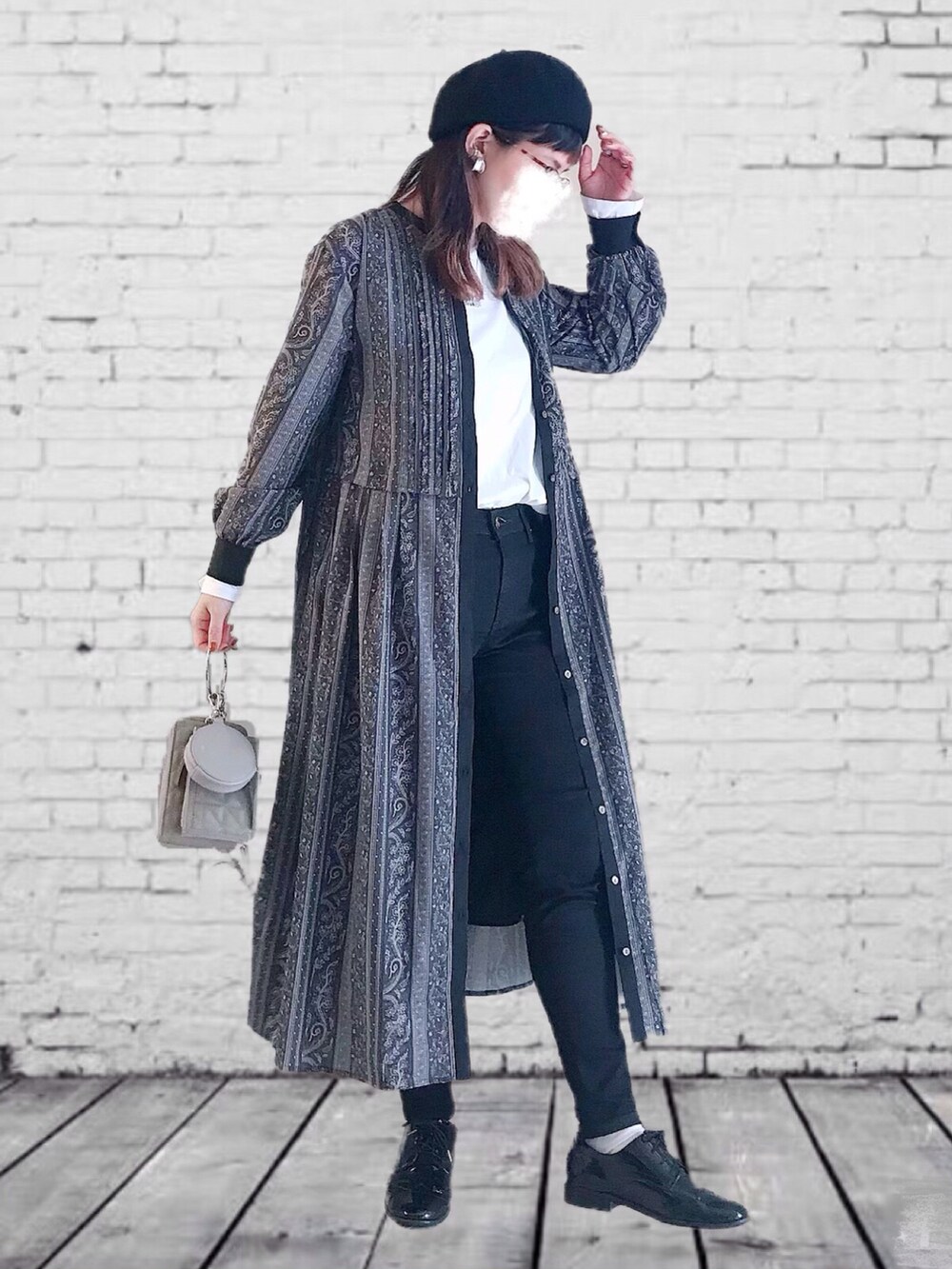 ブラック系のワンピース、ブラック系のデニムパンツ、ホワイト系のTシャツ/カットソーを着用したレディースの秋コーディネートの2枚目の写真