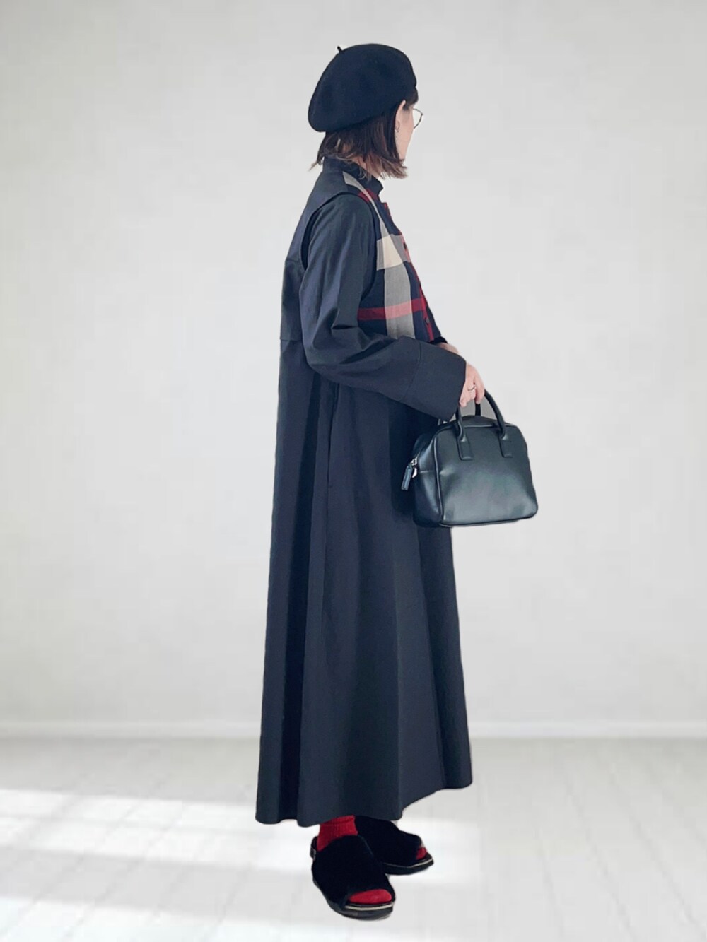 ブラック系のワンピース、ブラック系のボストンバッグ、ブラック系のサンダルを着用したレディースの秋コーディネートの4枚目の写真