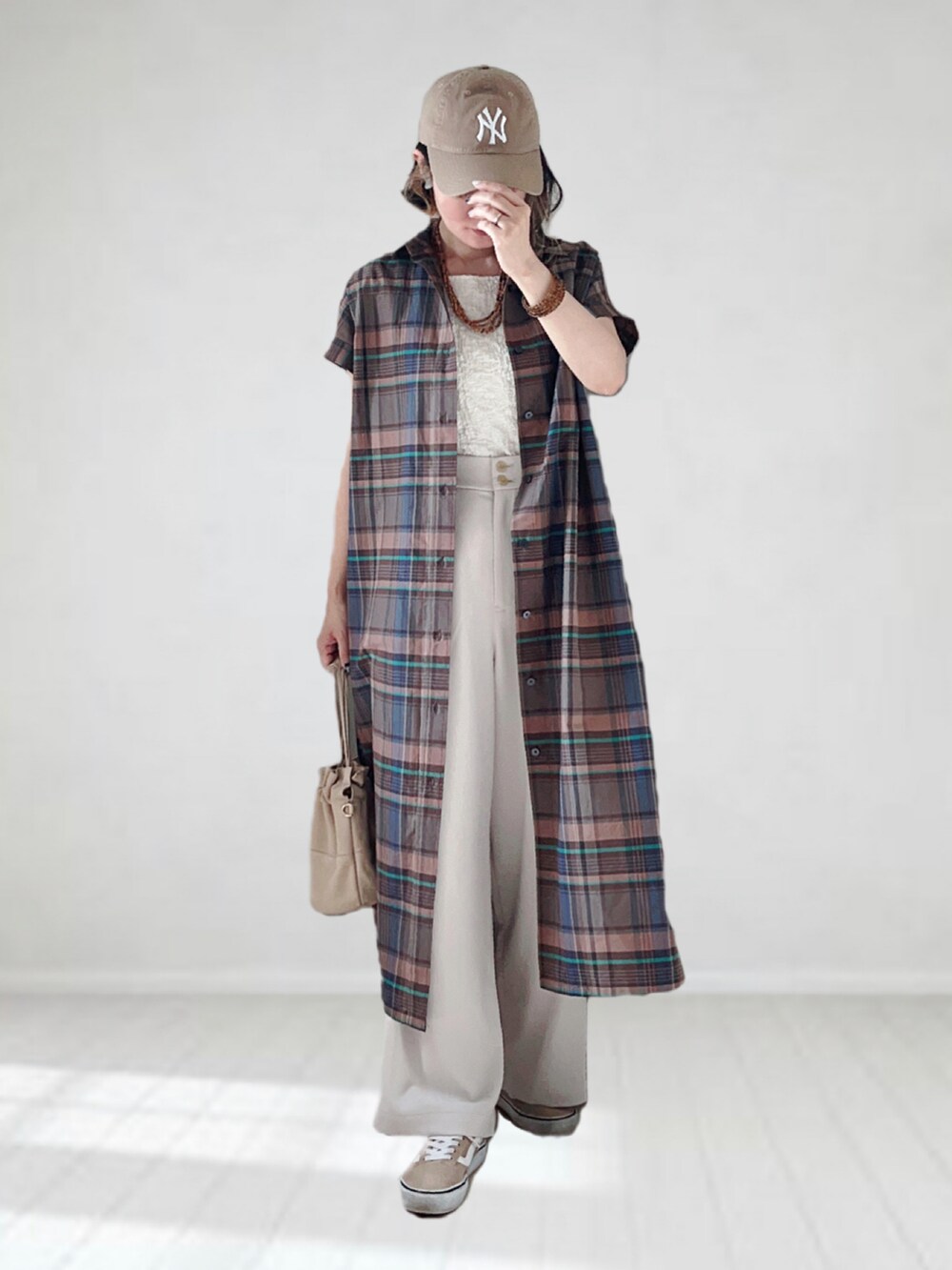 ブラウン系のワンピース、ホワイト系のタンクトップ、ホワイト系のその他パンツを着用したレディースの夏コーディネートの2枚目の写真