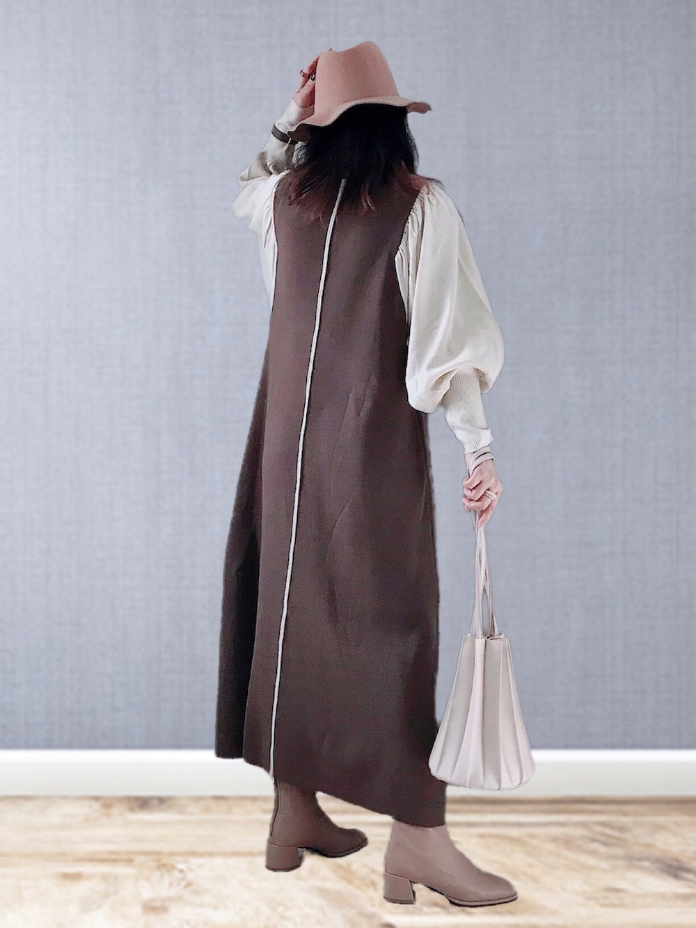 ブラウン系のワンピース、ベージュ系のショルダーバッグ、ベージュ系のブーツを着用したレディースの冬コーディネートの3枚目の写真