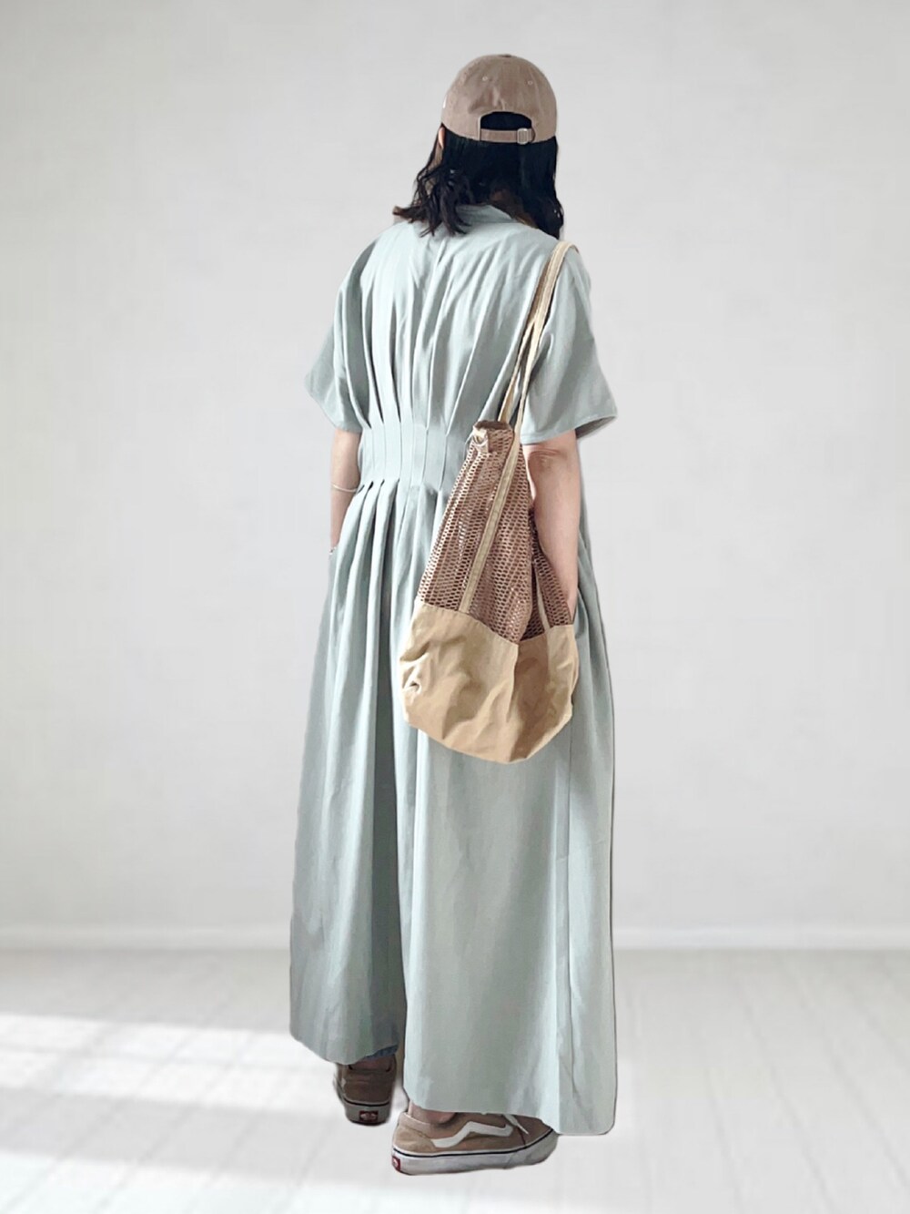 グリーン系のワンピース、ホワイト系のキャミソール、ブルー系のデニムパンツを着用したレディースの夏コーディネートの3枚目の写真