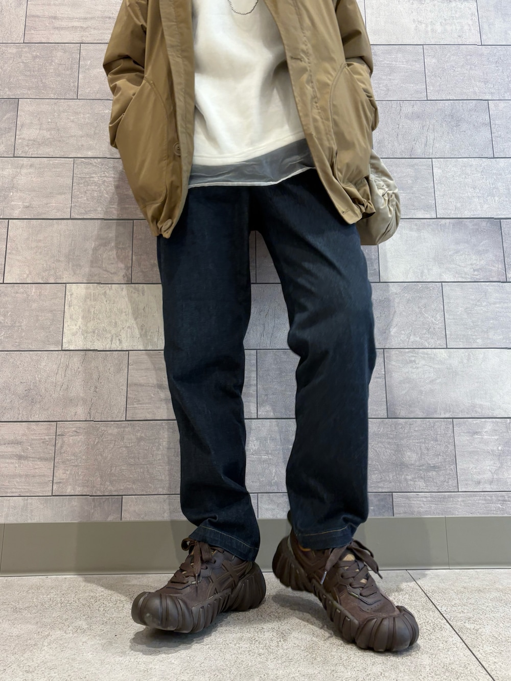 ベージュ系のミリタリージャケット、ホワイト系のスウェット、ブルー系のその他パンツを着用したレディースの春コーディネートの4枚目の写真