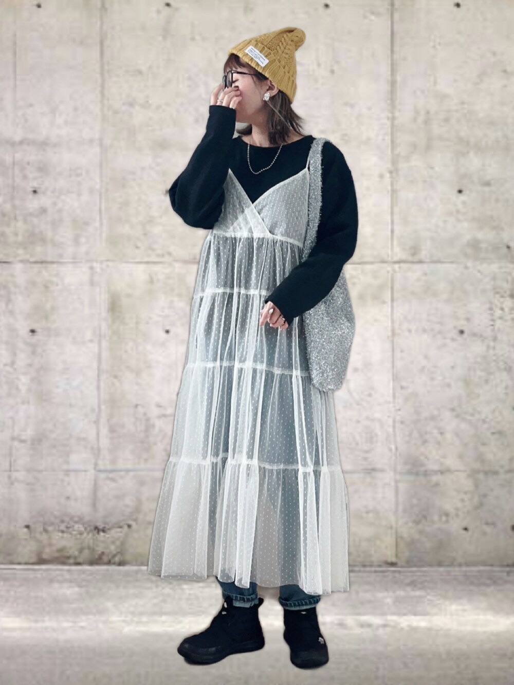 ブラック系のTシャツ/カットソー、ホワイト系のワンピース/ドレス、ブルー系のデニムパンツを着用したレディースの冬コーディネートの4枚目の写真