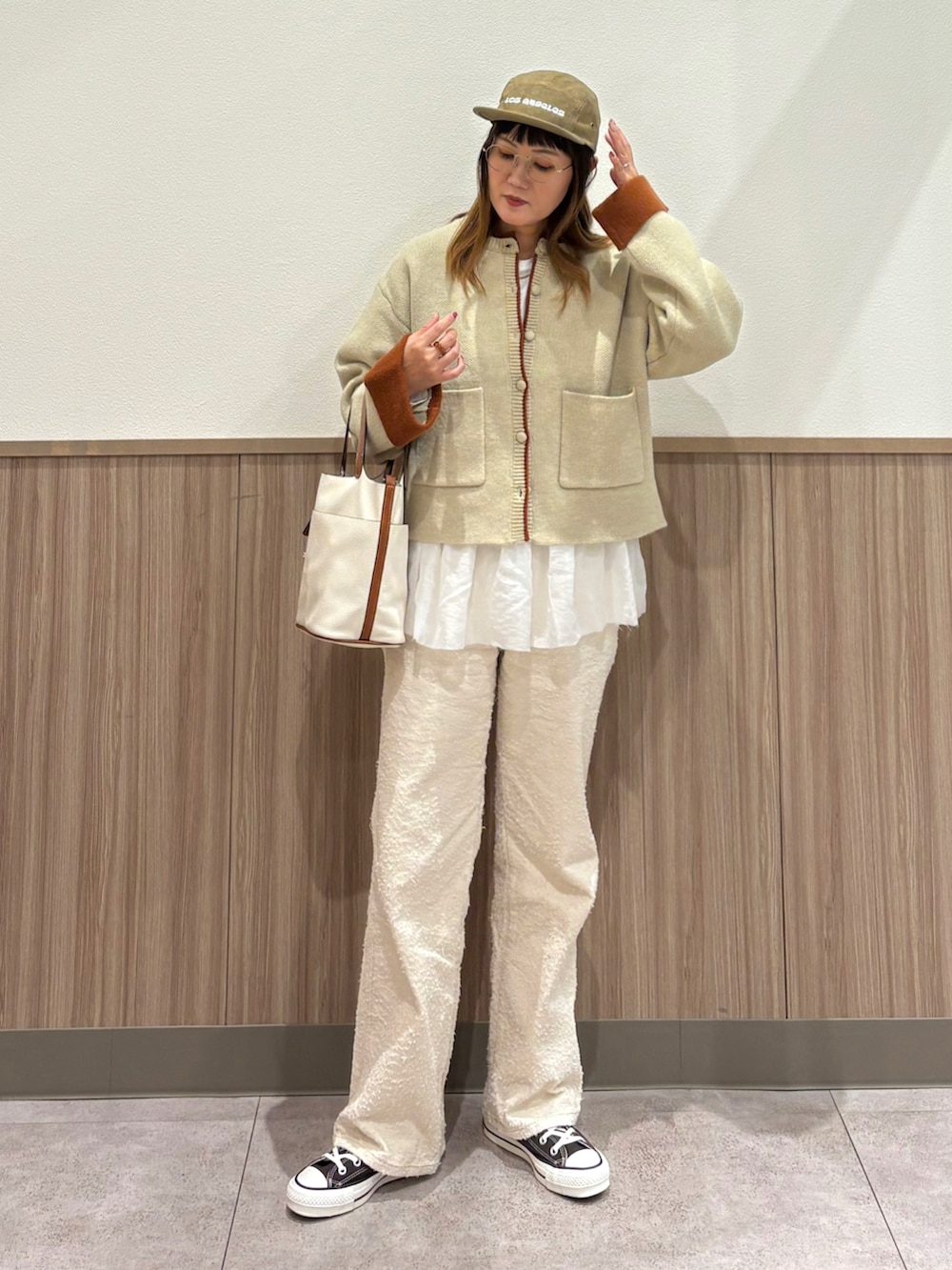 ホワイト系のカーディガン/ボレロ、ベージュ系のその他パンツ、ブラウン系のスニーカーを着用したレディースの秋コーディネートの2枚目の写真