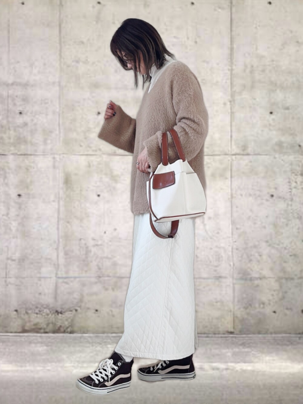 ブラウン系のニット/セーター、ホワイト系のTシャツ/カットソー、ホワイト系のスカートを着用したレディースの春コーディネートの3枚目の写真