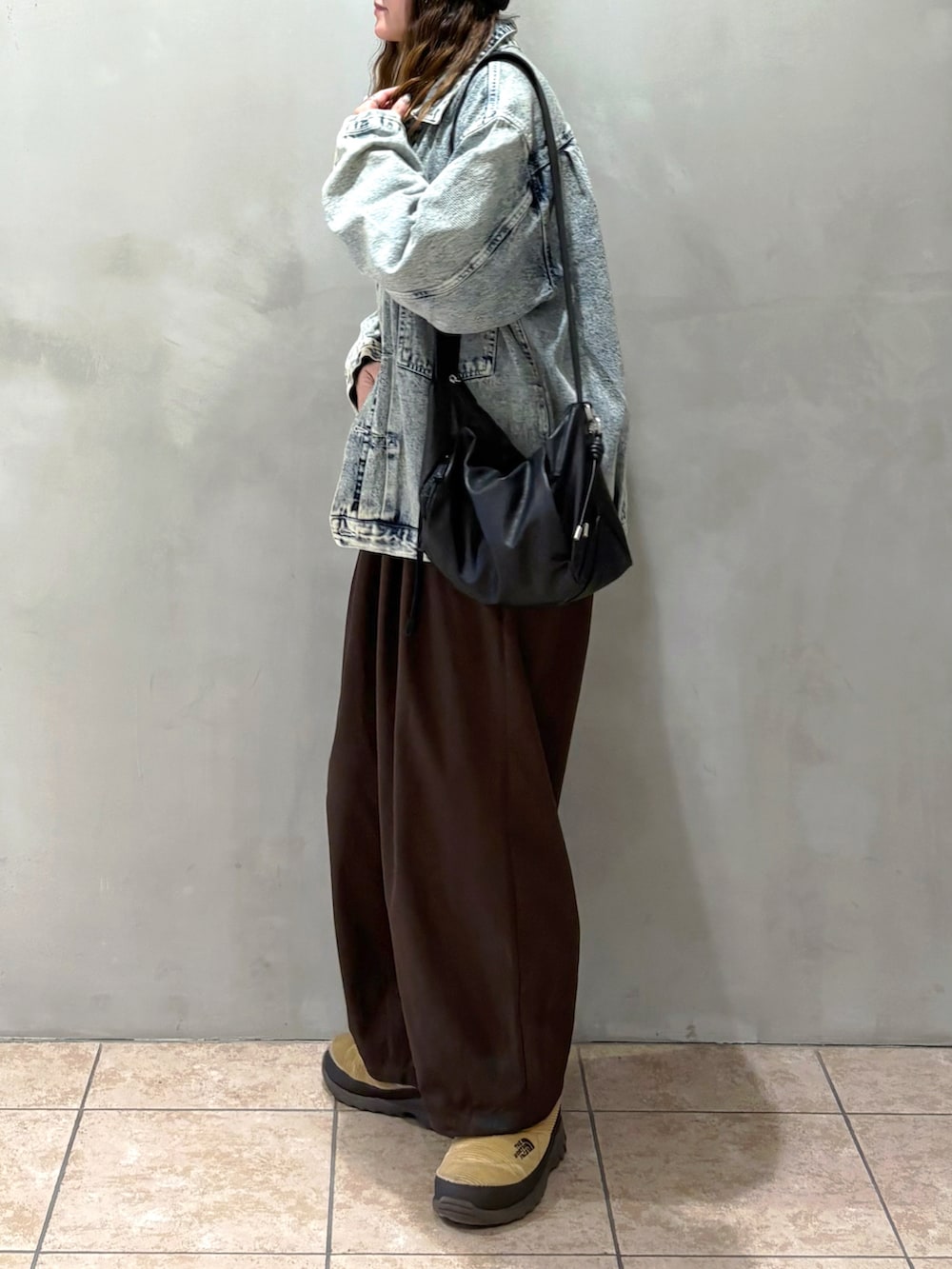 ブルー系のブルゾン、ブラウン系のその他パンツ、ブラック系のショルダーバッグを着用したレディースの冬コーディネートの3枚目の写真