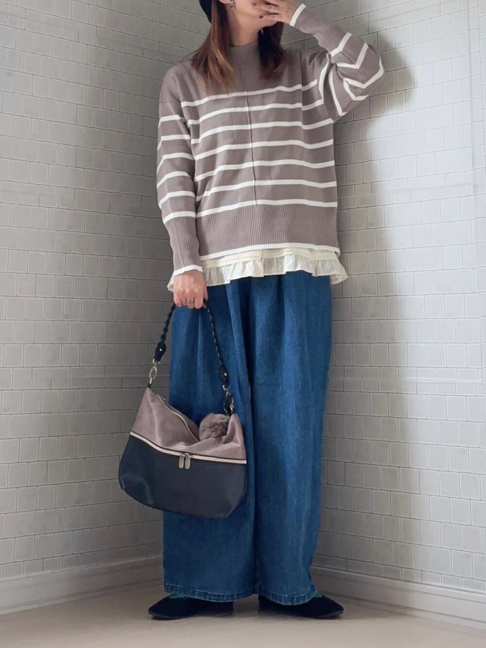 ベージュ系のニット/セーター、ブラック系のショルダーバッグ、ブルー系のデニムパンツを着用したレディースの冬コーディネートの3枚目の写真