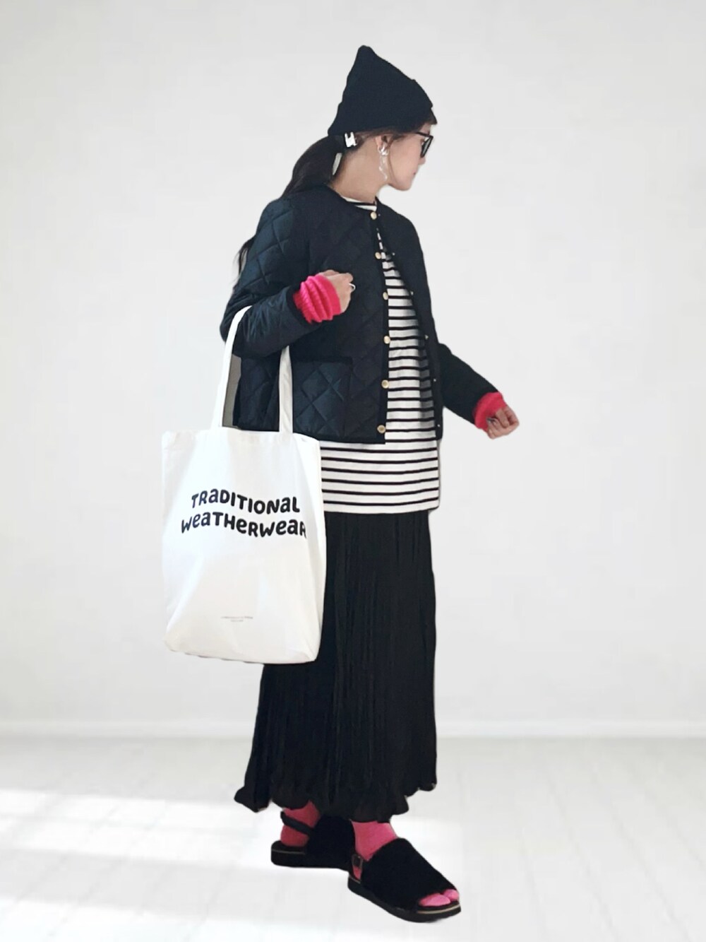 ブラック系のノーカラージャケット、ホワイト系のTシャツ/カットソー、ブラック系のスカートを着用したレディースの秋コーディネートの2枚目の写真