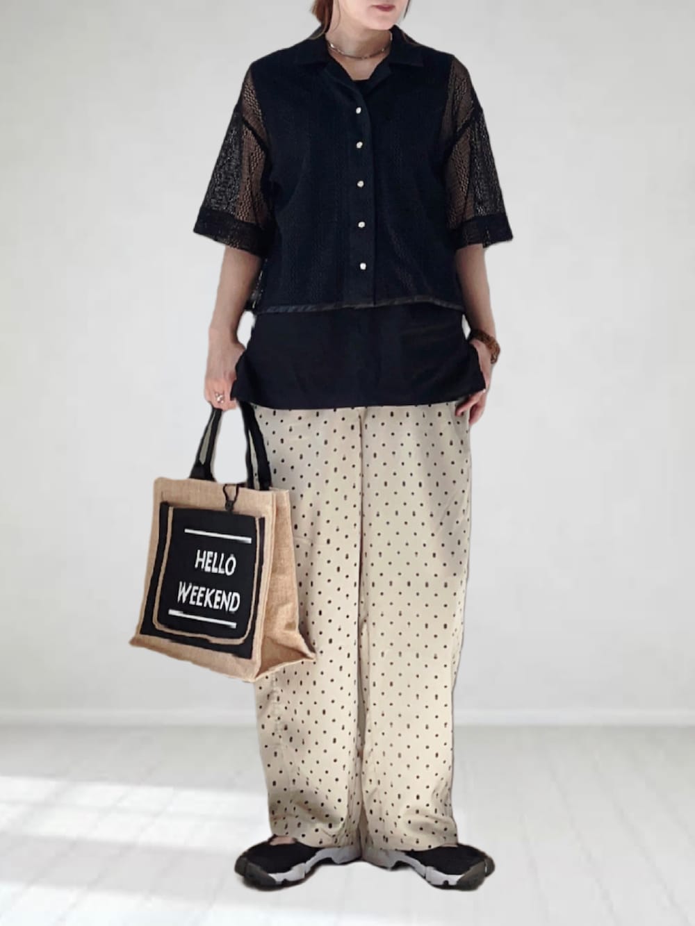 ブラック系のシャツ/ブラウス、ベージュ系のその他パンツ、ブラック系のかごバッグを着用したレディースの春コーディネートの2枚目の写真