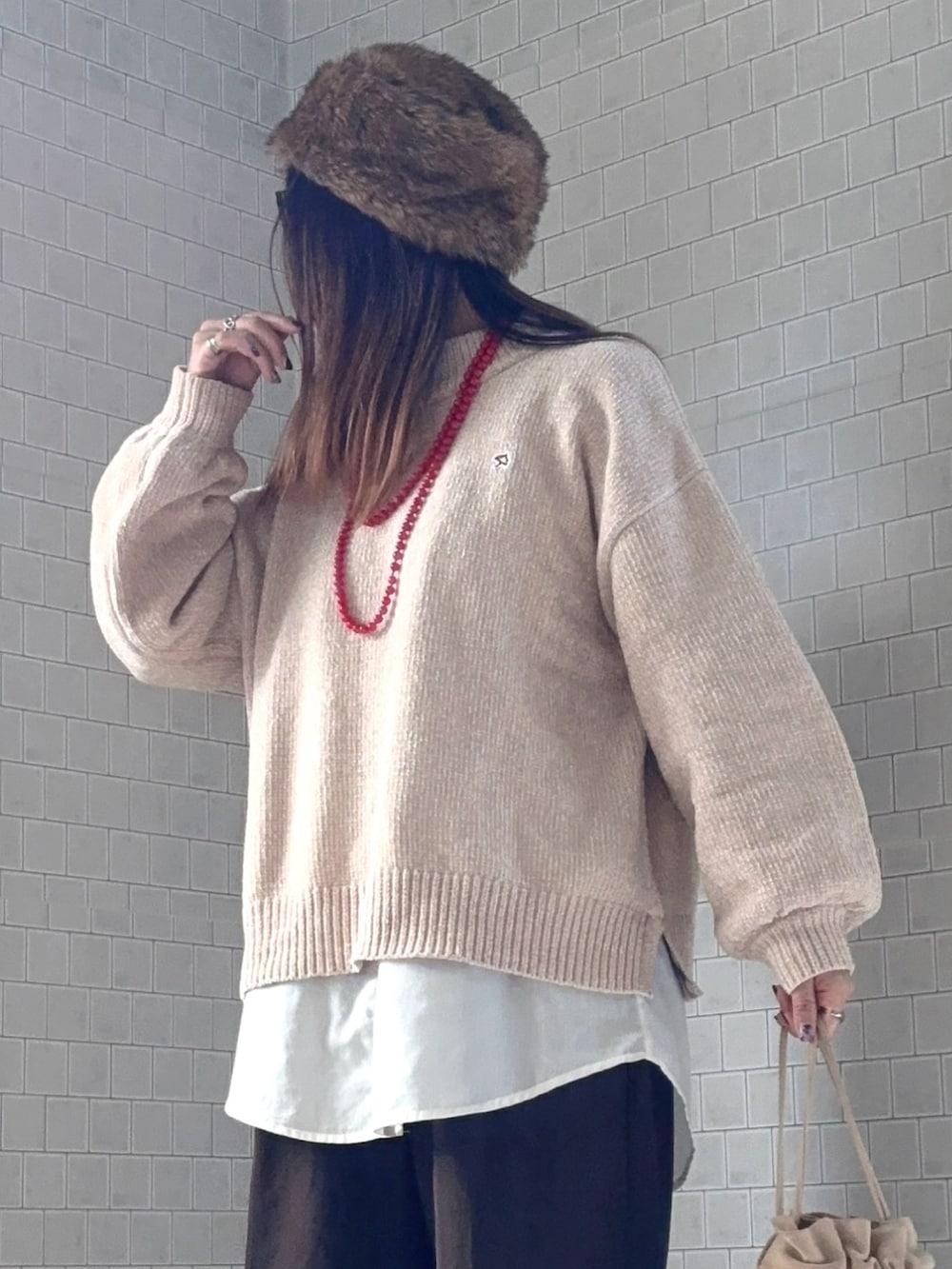 ベージュ系のニット/セーター、ブラウン系のその他パンツ、ブラウン系のブーツを着用したレディースの冬コーディネートの4枚目の写真