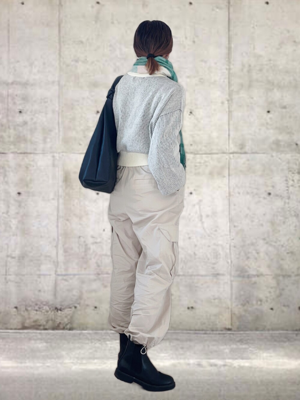 イエロー系のニット/セーター、ホワイト系のその他パンツ、ブラック系のトートバッグを着用したレディースの秋コーディネートの4枚目の写真