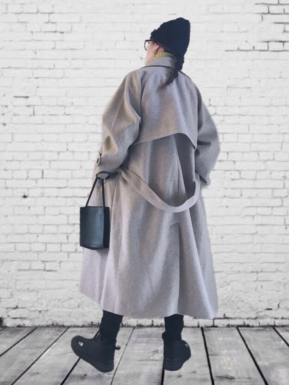 ベージュ系のステンカラーコート、イエロー系のニット/セーター、ホワイト系のTシャツ/カットソーを着用したレディースの秋コーディネートの3枚目の写真