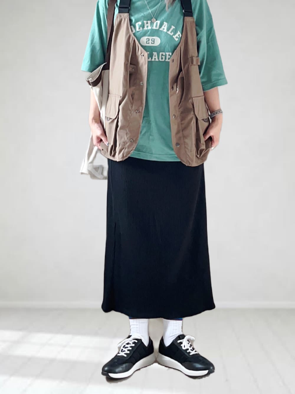 ブラック系のスニーカー、グリーン系のTシャツ/カットソー、ブラウン系のベストを着用したレディースの夏コーディネートの4枚目の写真