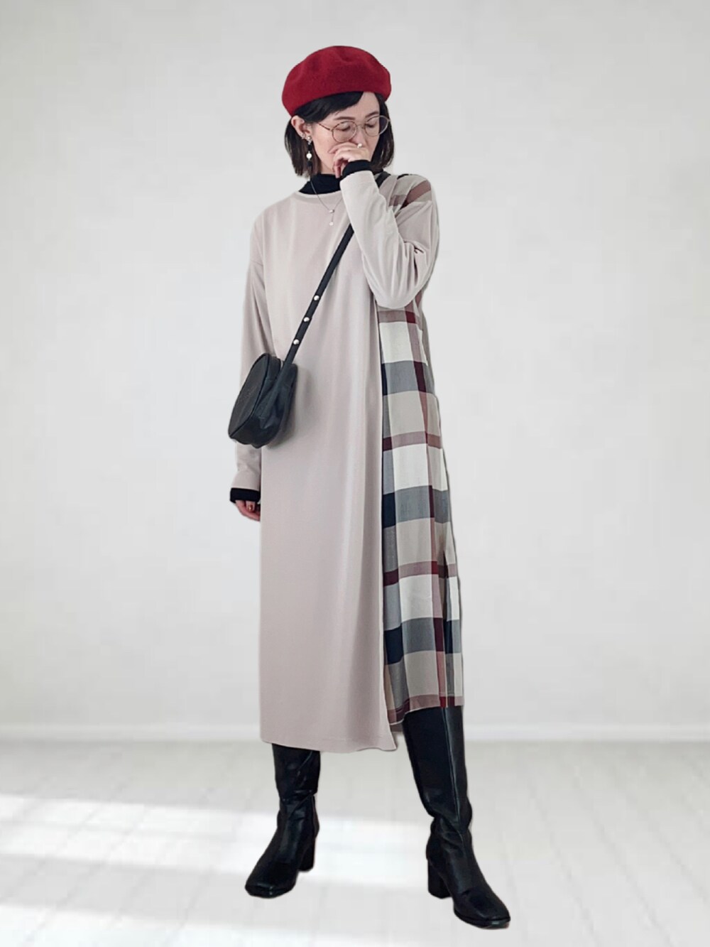 ベージュ系のワンピース、ブラック系のショルダーバッグ、ブラック系のブーツを着用したレディースの秋コーディネートの2枚目の写真