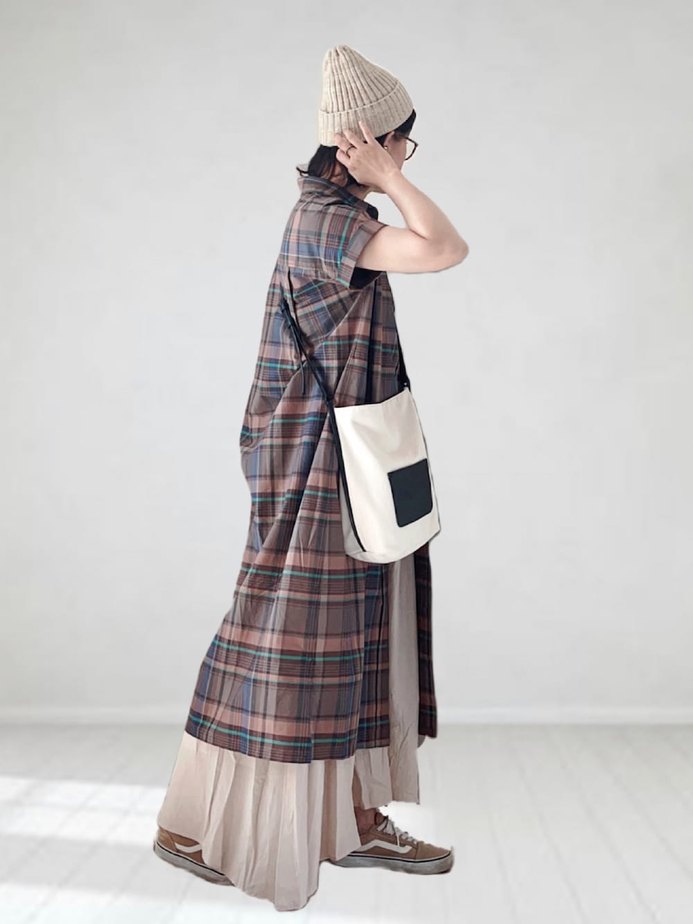 ブラウン系のワンピース、ホワイト系のスカート、ホワイト系のショルダーバッグを着用したレディースの夏コーディネートの2枚目の写真