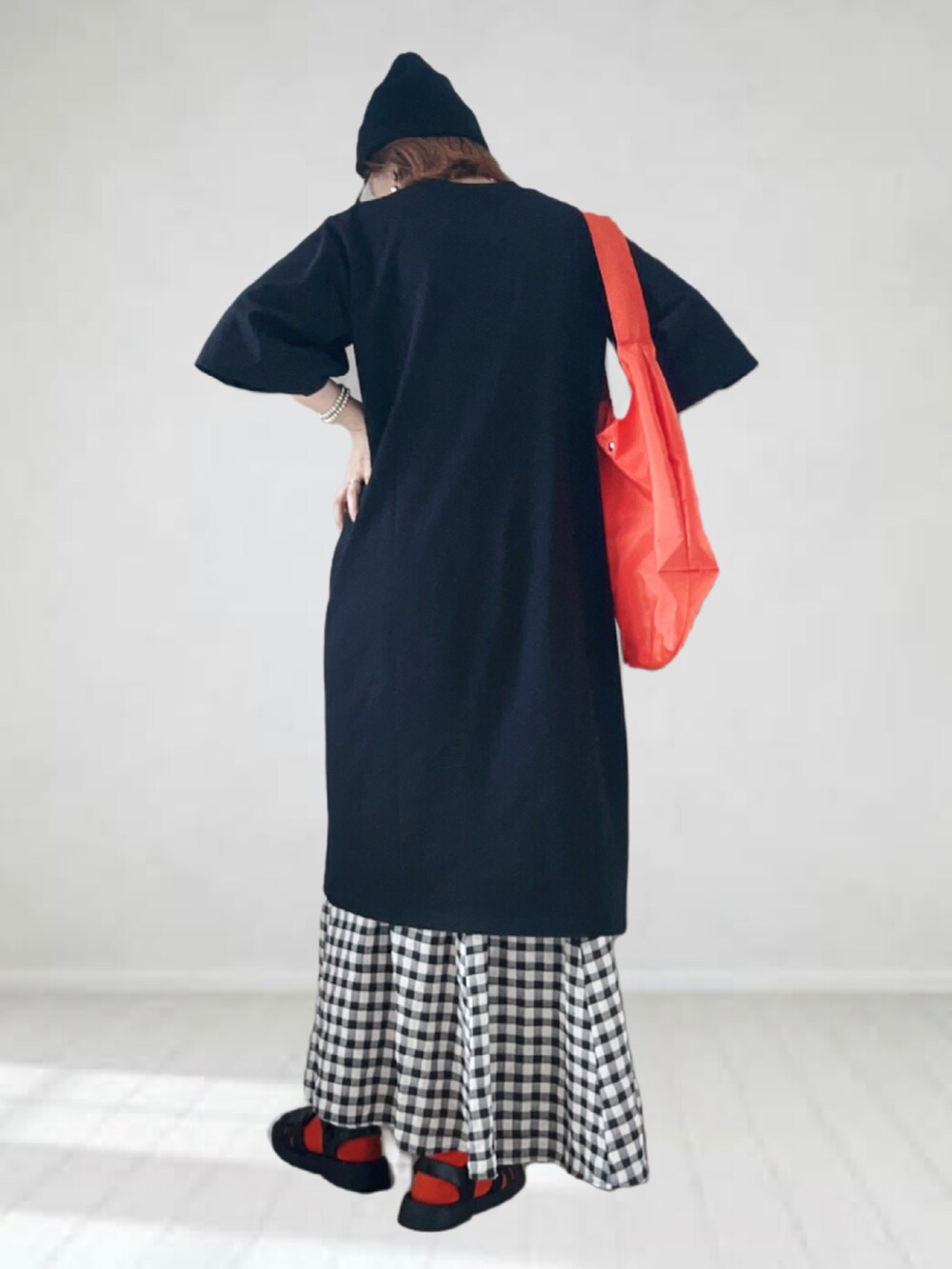 ブラック系のワンピース、ブラック系のスカート、ブラック系のサンダルを着用したレディースの夏コーディネートの2枚目の写真