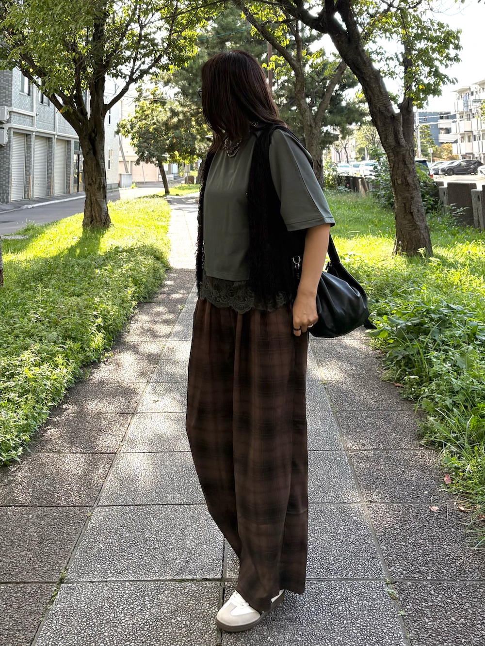 ブラウン系のその他パンツ、ブラック系のショルダーバッグ、ホワイト系のスニーカーを着用したレディースの秋コーディネートの2枚目の写真