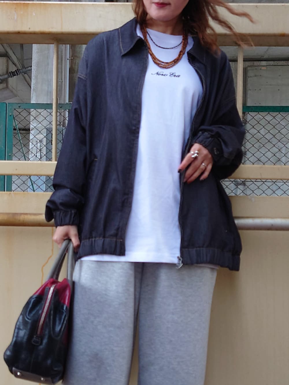 ブラック系のブルゾン、ホワイト系のTシャツ/カットソー、ホワイト系のスニーカーを着用したレディースの夏コーディネートの5枚目の写真