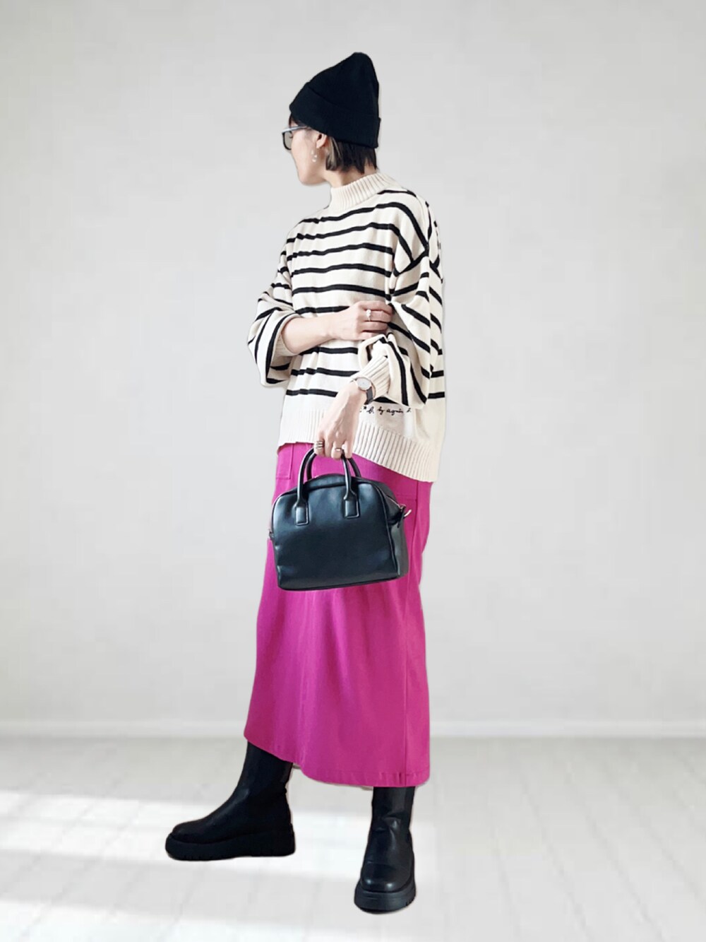 ホワイト系のニット/セーター、パープル系のスカート、ブラック系のボストンバッグを着用したレディースの秋コーディネートの2枚目の写真